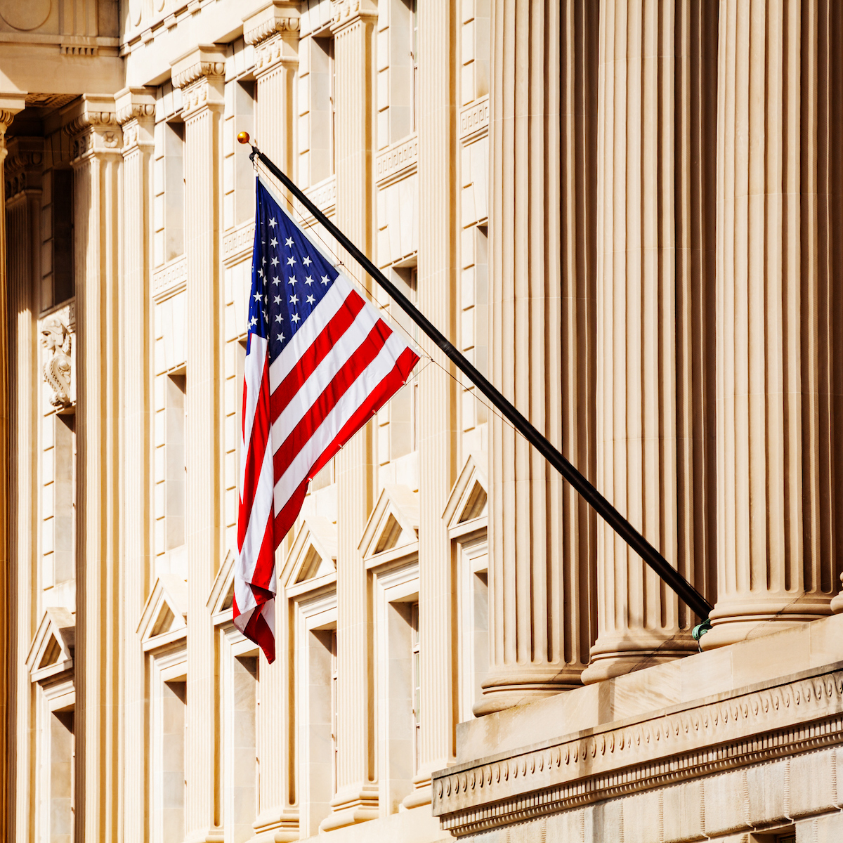 US flag over government building in Washington, DC